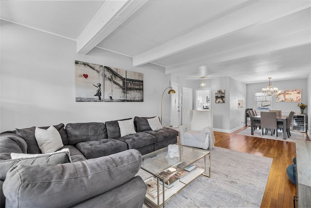 living room with an inviting chandelier, beamed ceiling, baseboards, and wood finished floors