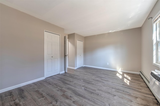 empty room with a wealth of natural light, baseboards, and wood finished floors