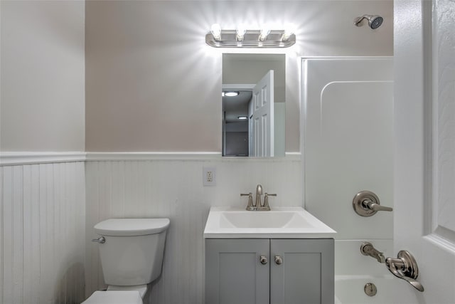 full bathroom featuring wainscoting, vanity, toilet, and tub / shower combination