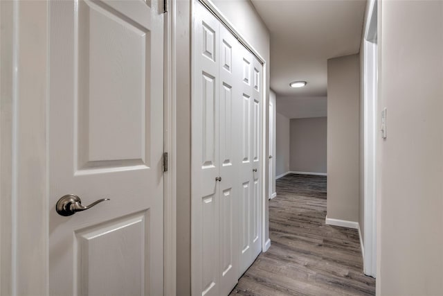 hall featuring baseboards and light wood finished floors