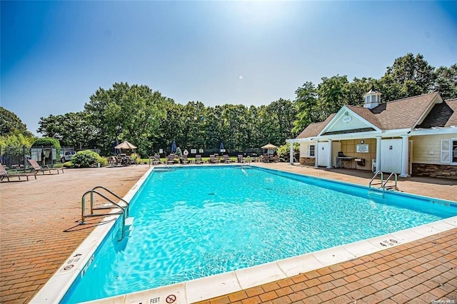 community pool featuring a patio and fence