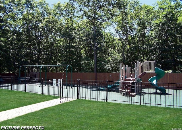 community play area featuring a yard and fence