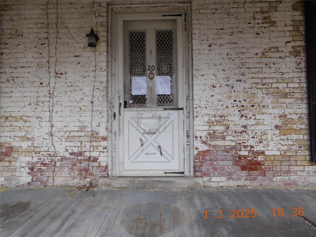 entrance to property featuring brick siding