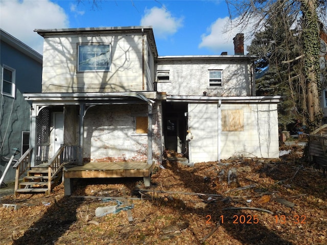 back of property featuring a porch and a chimney