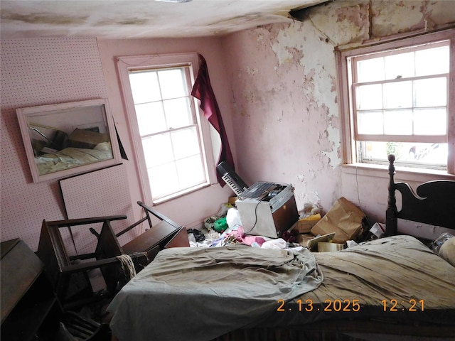 bedroom with wallpapered walls and multiple windows