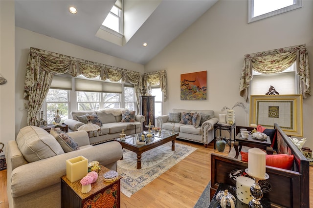 living room with a skylight, high vaulted ceiling, wood finished floors, and recessed lighting