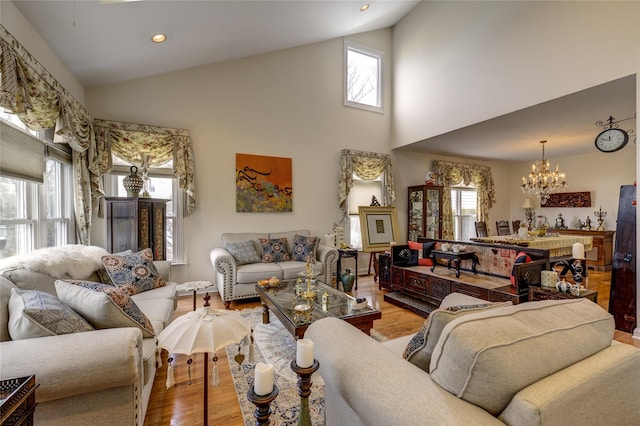 living area featuring a wealth of natural light, a notable chandelier, recessed lighting, and wood finished floors