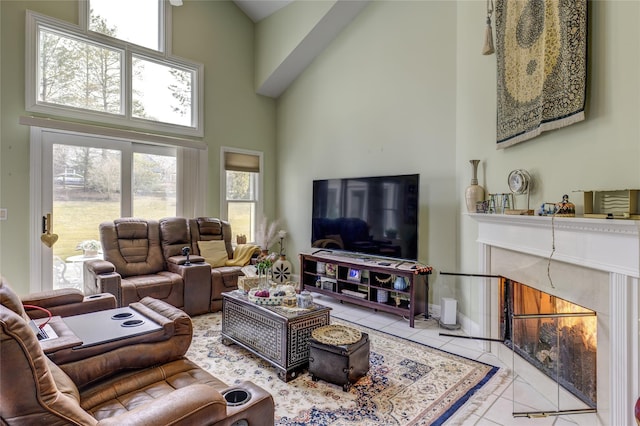 living area with a high end fireplace, tile patterned flooring, a towering ceiling, and baseboards