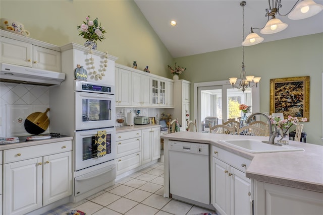 kitchen featuring a warming drawer, light tile patterned floors, a sink, white appliances, and under cabinet range hood