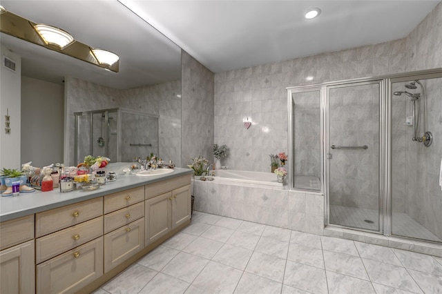 bathroom featuring a stall shower, visible vents, a garden tub, tile patterned flooring, and vanity