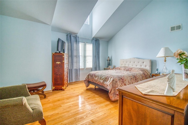 bedroom with lofted ceiling, visible vents, and light wood-style floors