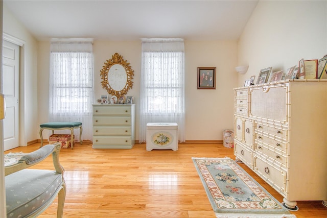 sitting room featuring plenty of natural light, baseboards, and wood finished floors