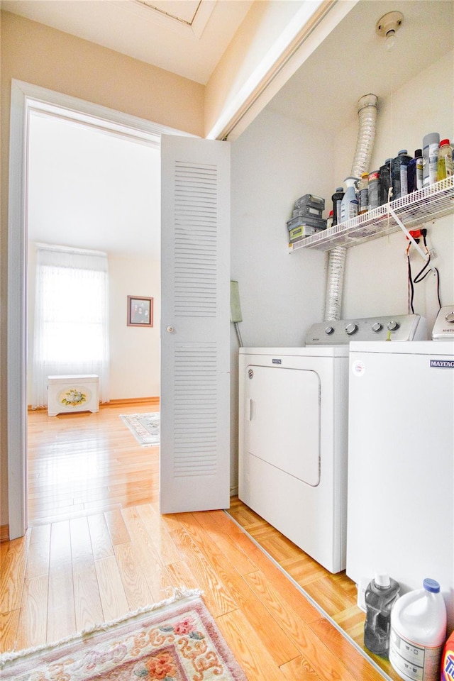 laundry area with light wood-type flooring, laundry area, and separate washer and dryer