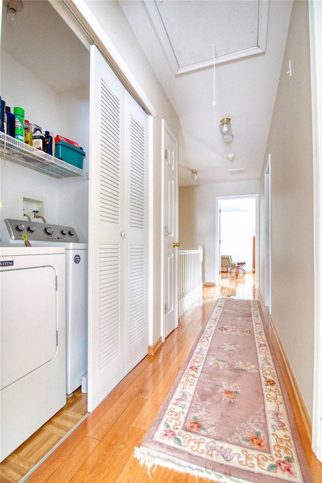 interior space with light wood finished floors, washer and clothes dryer, attic access, and baseboards