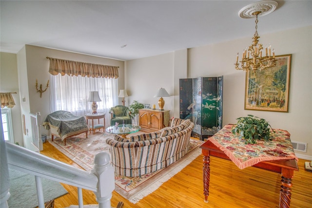 living room featuring a chandelier, wood finished floors, and visible vents