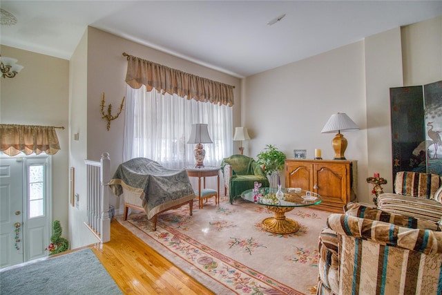 sitting room featuring baseboards, wood finished floors, and a healthy amount of sunlight