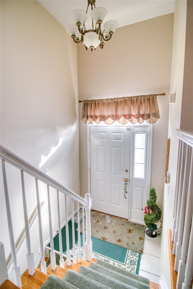 entryway featuring stairs, tile patterned floors, and a notable chandelier