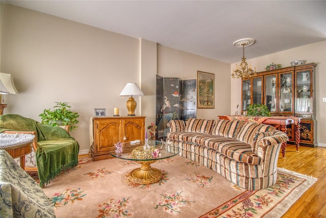 living room featuring baseboards, a chandelier, and wood finished floors