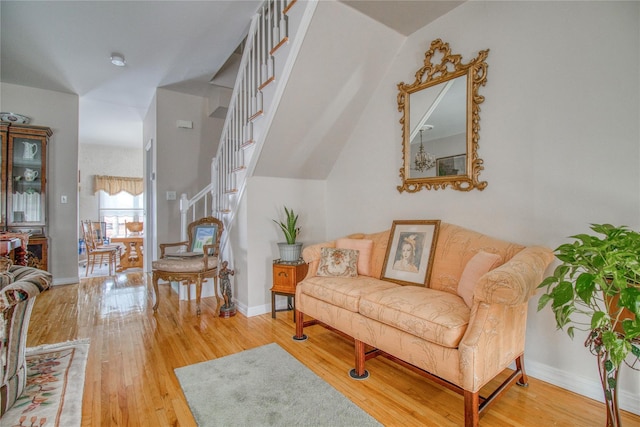 living area with stairs, wood finished floors, and baseboards