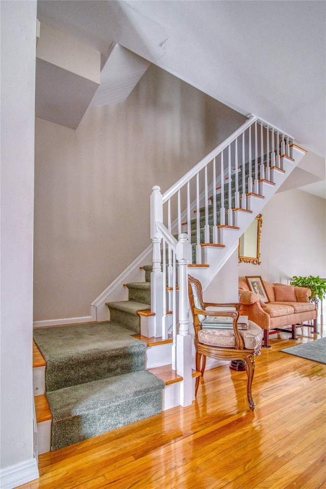 staircase featuring baseboards and wood finished floors