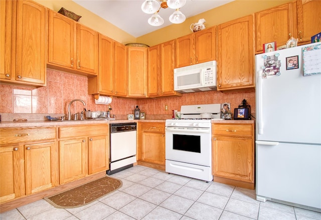 kitchen with white appliances, light tile patterned floors, decorative backsplash, light countertops, and a sink