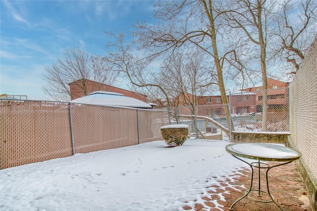 yard layered in snow featuring a fenced backyard