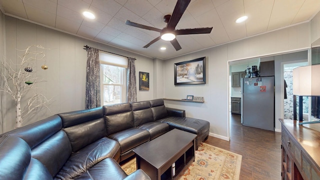 living room with dark wood-style flooring, recessed lighting, ornamental molding, a ceiling fan, and baseboards