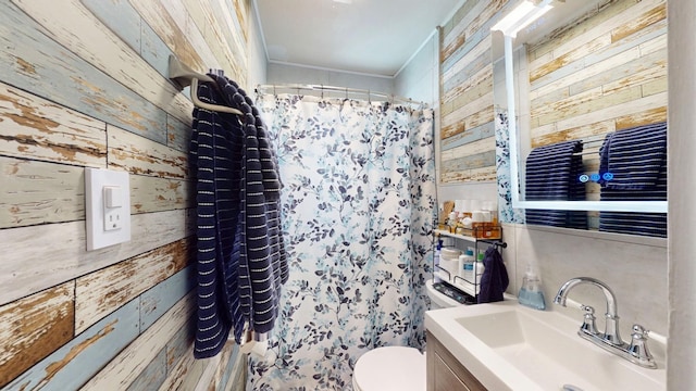 full bathroom with toilet, wooden walls, a shower with shower curtain, and vanity