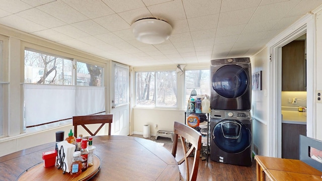 sunroom featuring stacked washer and clothes dryer and a healthy amount of sunlight