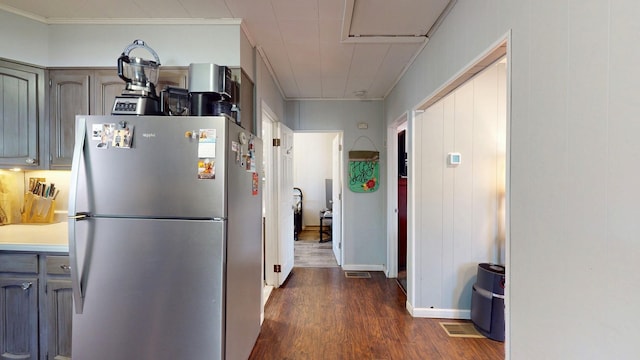 kitchen featuring dark wood-type flooring, freestanding refrigerator, light countertops, crown molding, and gray cabinetry