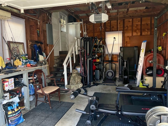 garage featuring a workshop area, electric panel, and a garage door opener