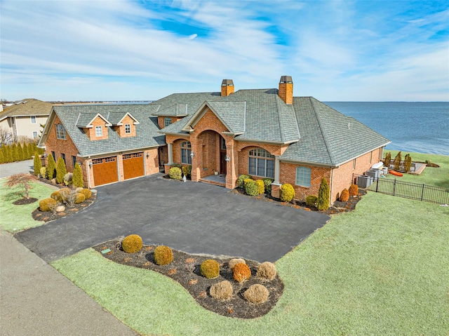 view of front of home with a front yard, fence, aphalt driveway, and brick siding