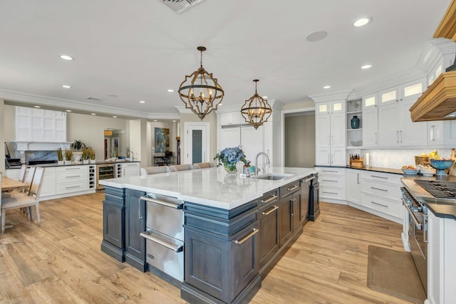 kitchen featuring white cabinets, double oven range, a sink, and a warming drawer