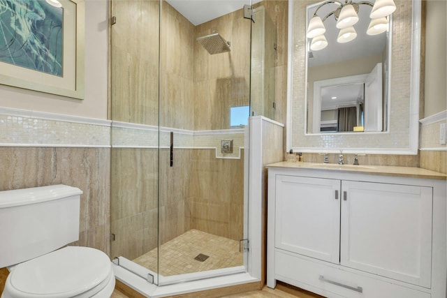 bathroom featuring toilet, vanity, a shower stall, and tile walls