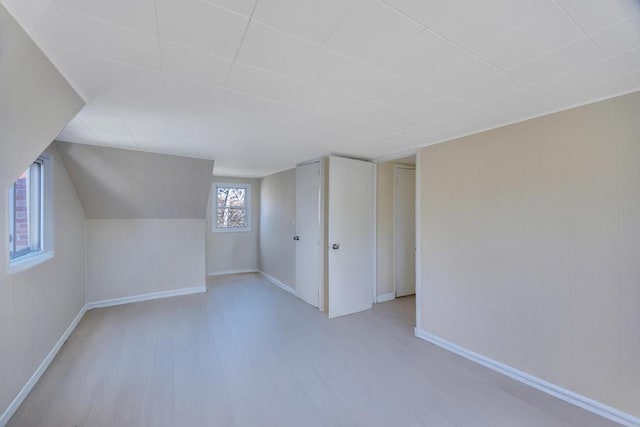 bonus room featuring vaulted ceiling, wood finished floors, and baseboards