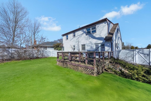 back of house featuring a fenced backyard, a yard, and a wooden deck