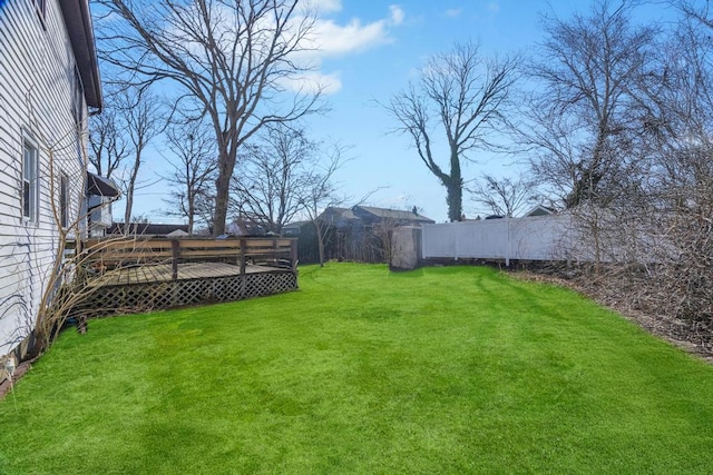 view of yard featuring a wooden deck and fence