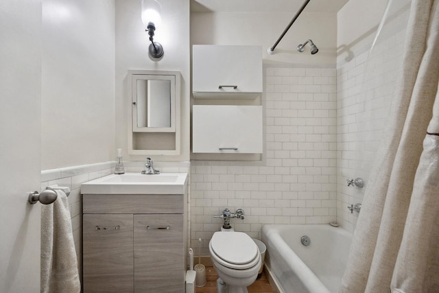 full bath with tile walls, toilet, shower / tub combo, and vanity