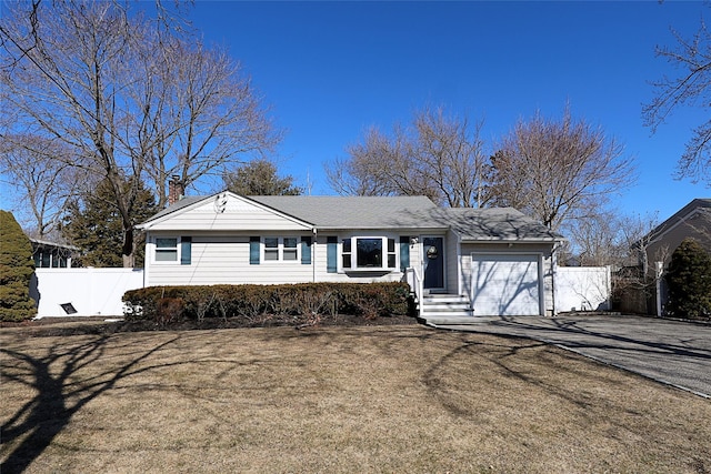 ranch-style home with a garage, a chimney, fence, and aphalt driveway