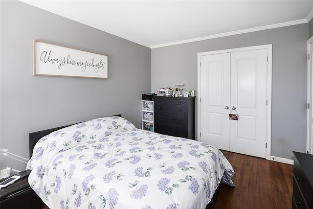 bedroom with ornamental molding, a closet, dark wood finished floors, and baseboards