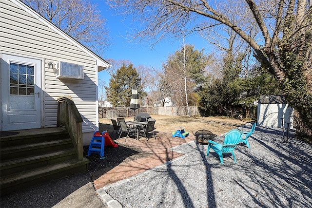 view of yard featuring a fire pit, a patio, a wall mounted AC, and fence