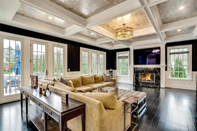 living area featuring dark wood-style floors, a high end fireplace, a decorative wall, and beam ceiling