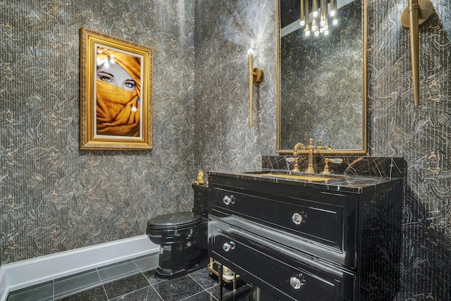 bathroom featuring baseboards, toilet, wallpapered walls, vanity, and tile patterned flooring