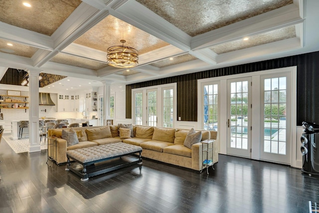 living room featuring coffered ceiling, decorative columns, dark wood-style flooring, beamed ceiling, and a notable chandelier