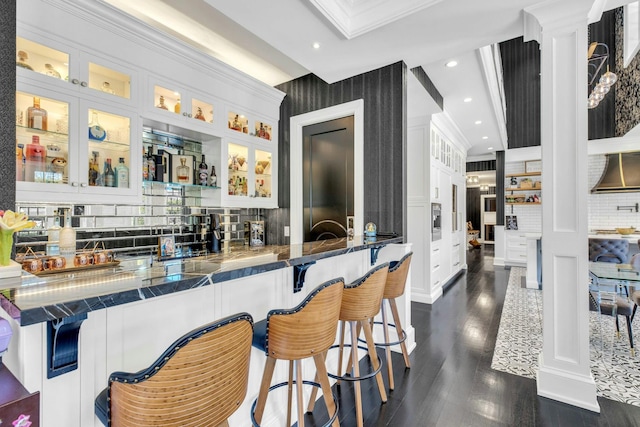 bar featuring decorative backsplash, ornamental molding, recessed lighting, and dark wood finished floors