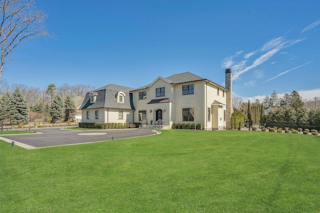 view of front of home featuring a front lawn, uncovered parking, and a chimney