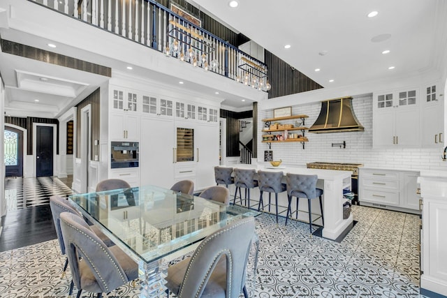 dining room featuring a high ceiling, crown molding, and recessed lighting