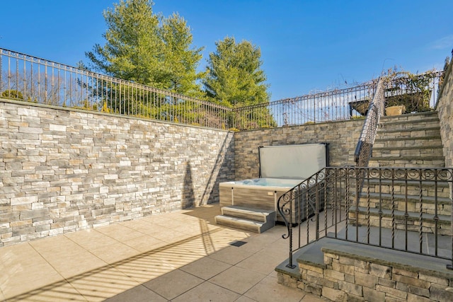 view of patio with fence and a hot tub