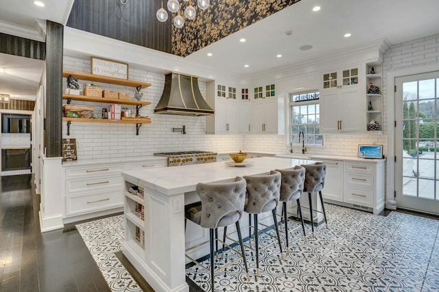 kitchen with white cabinetry, ornamental molding, open shelves, and custom exhaust hood