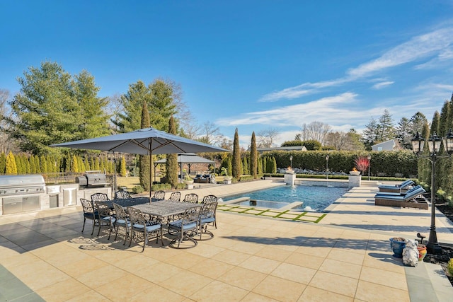 view of pool featuring a patio, exterior kitchen, a fenced in pool, and area for grilling
